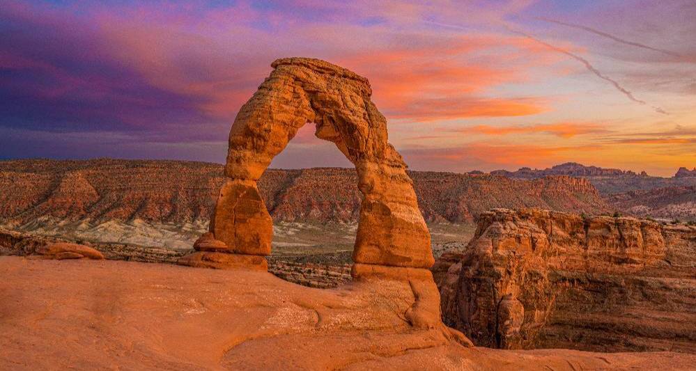 a landscape view of the delicate arch during a warm sunset