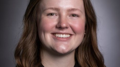 Image of Nicole Bingham with long brown hair in a black blouse smiling at the camera