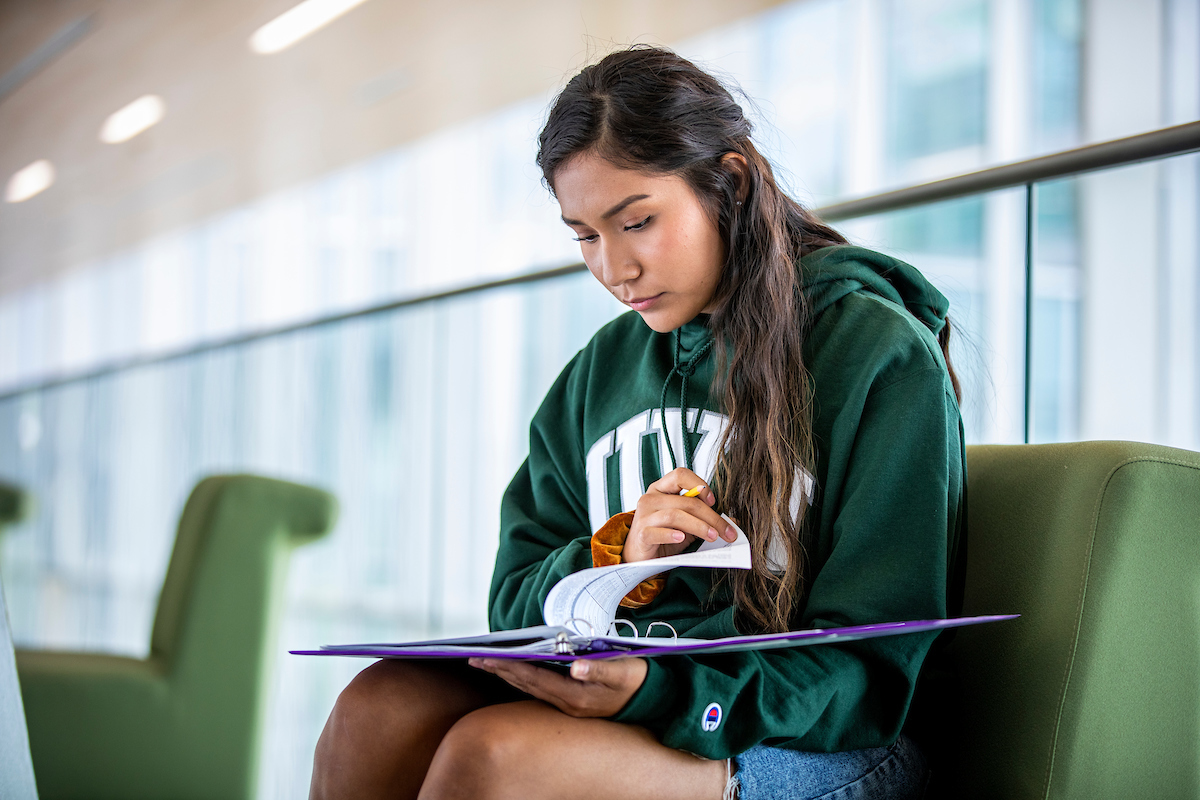 studying flipping through their notes written on a notebook