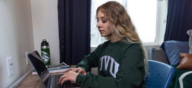 Student typing on their laptop