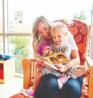 UVU graduate Shelby Snyder reads a book to her daughter in the Wee Care Center on UVU’s Orem Campus. 