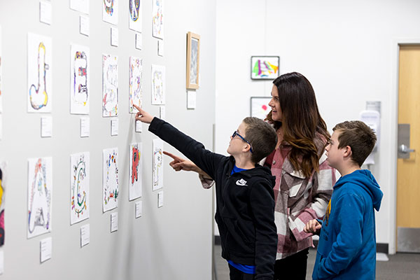 Art Show with a mom and her two sonds looking at art