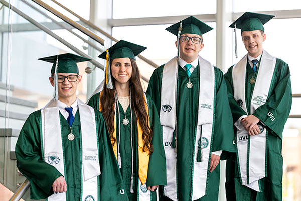 4 UVU graduates posing for a graduation photo