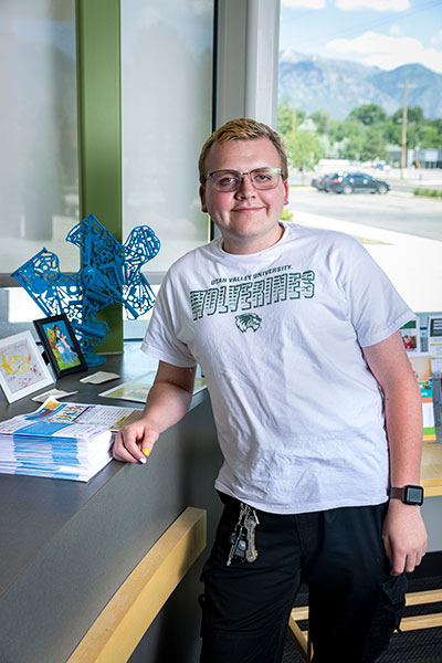 Image of a person leaning on a desk posing for the camera