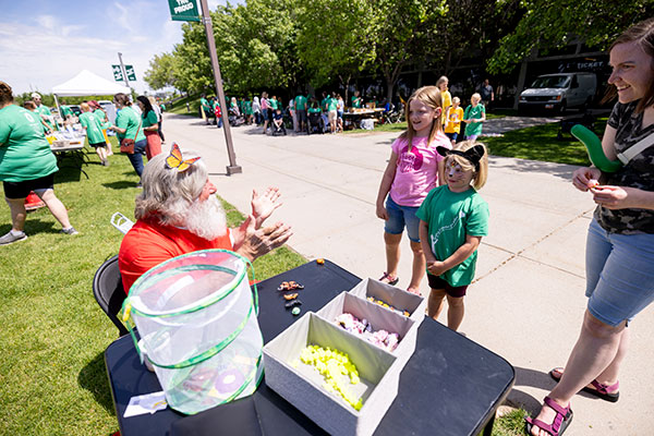 people at an outdoor event at a booth