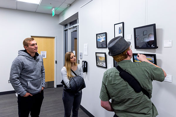 3 people looking at art at the MNCA art gallery