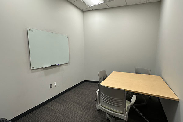 Image of a MNCA study room with a desk and whiteboard