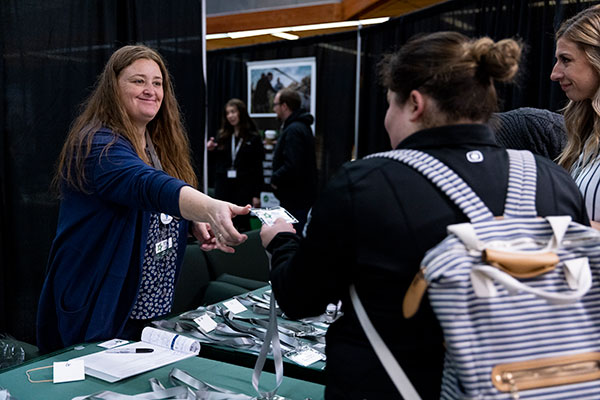 Someone from a table booth handing out badges