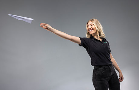 woman throwing a paper airplane