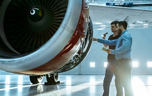 two people looking at a plane in a hangar