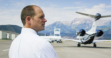 man on a runway with a plane in the background