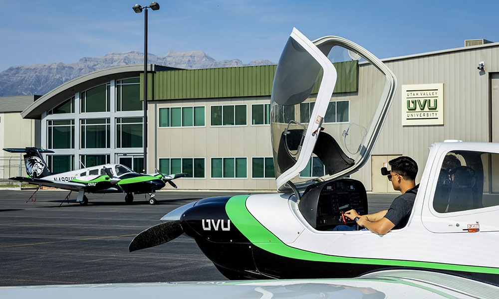 person sitting in an open plane cockpit