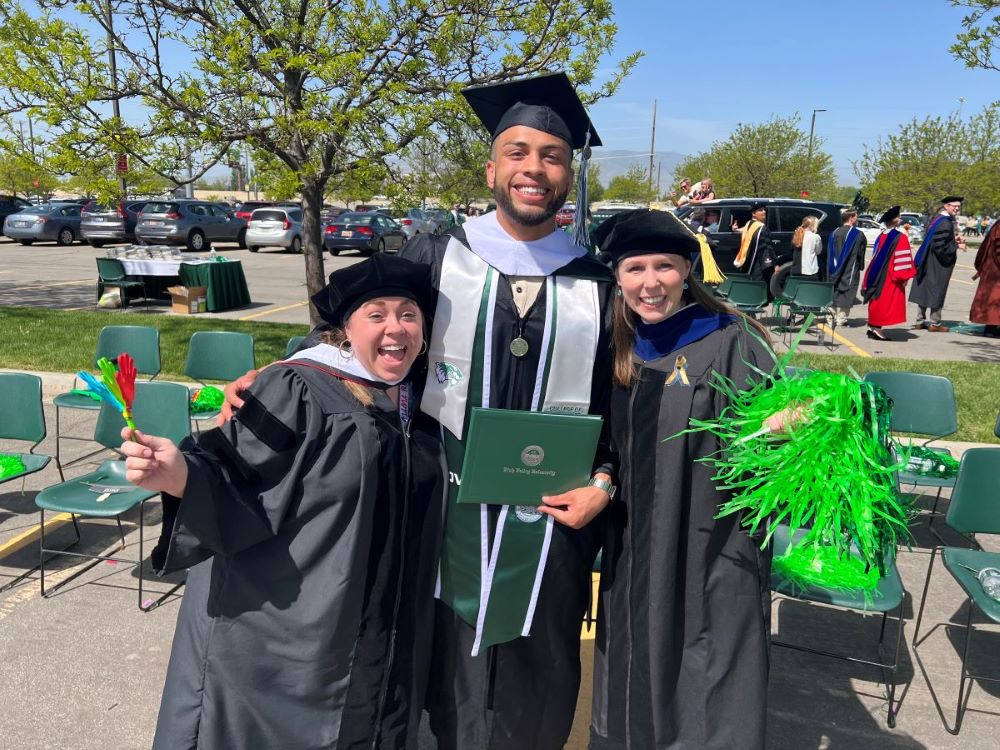 male graduate with two faculty