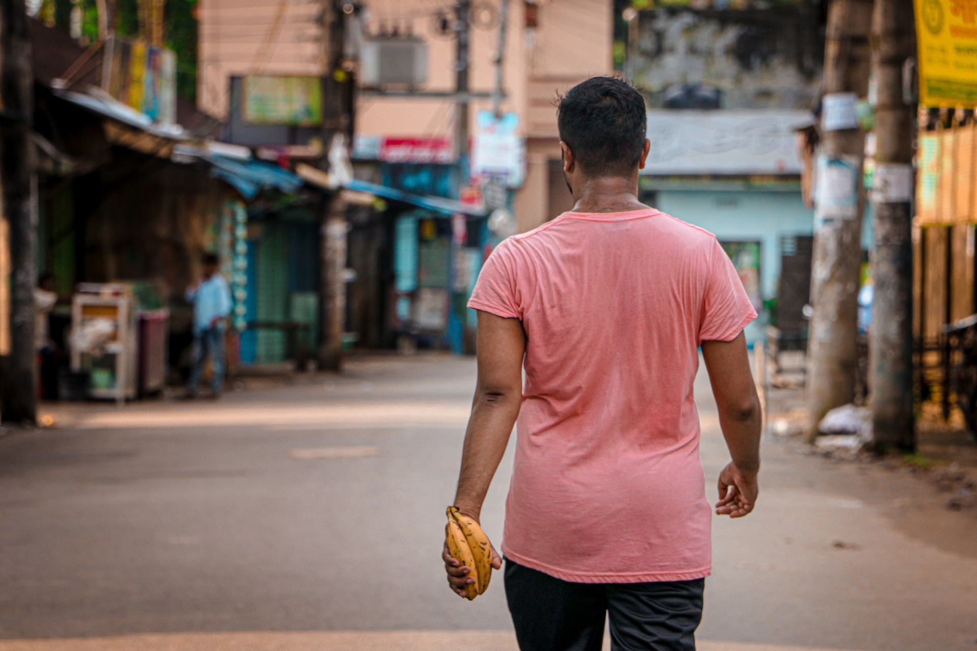 person's back as they walk through a community