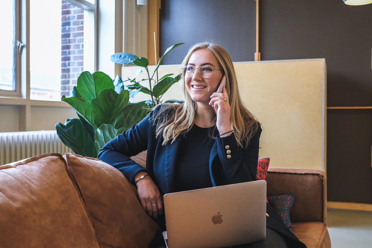 woman on phone with laptop on her lap