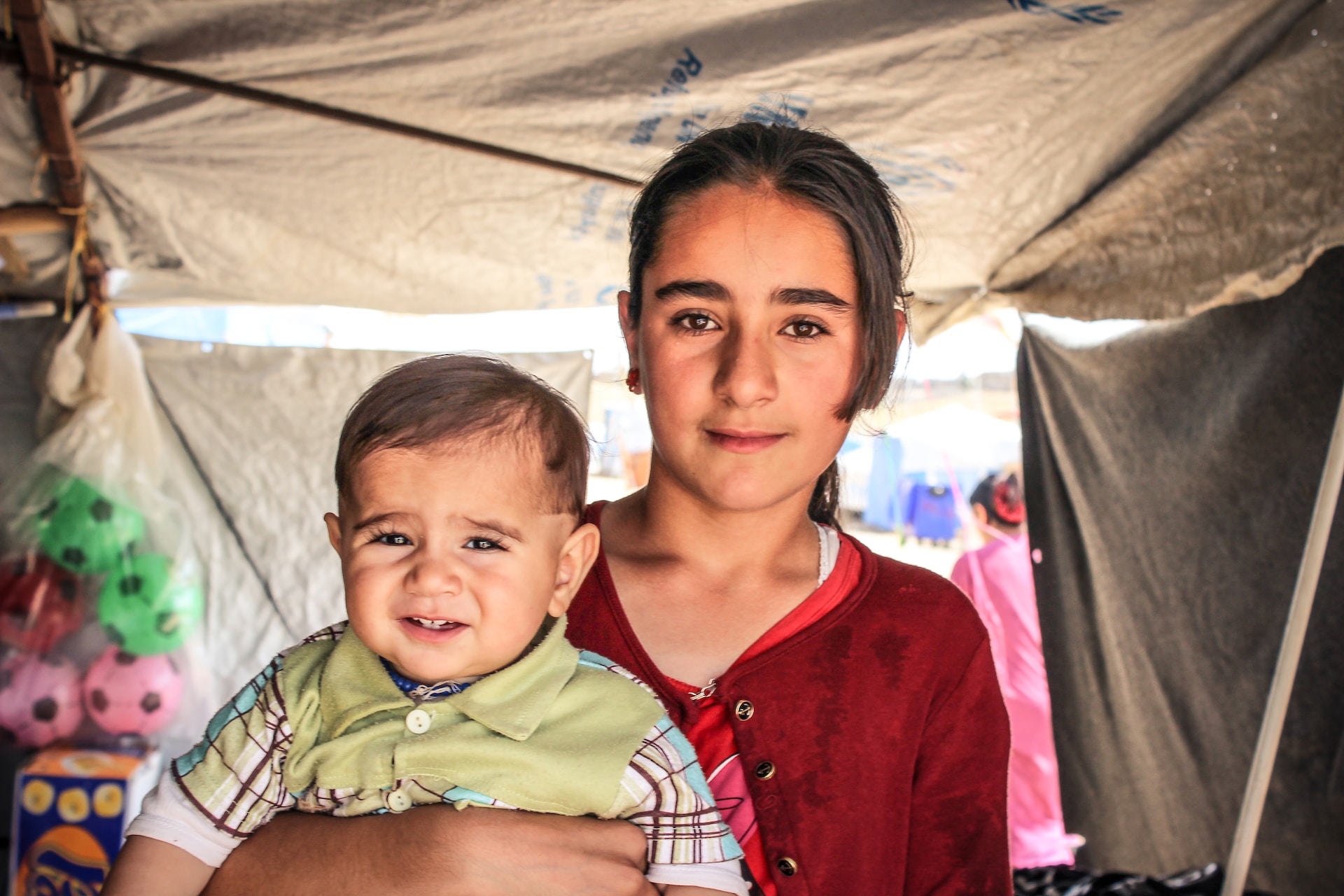 young girl holding a baby boy