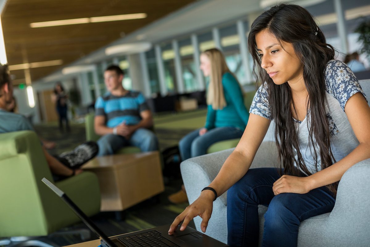 Overhead view of students working on homework in the Computer Science Building at UVU. The floor looks like a circuit board.