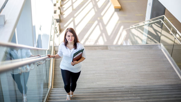 A childcare provider walking up some stairs.