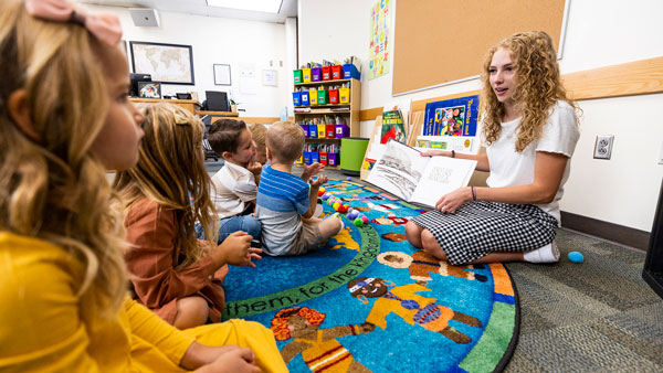 A childcare provider reading to a group of children