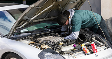 student working on a car engine