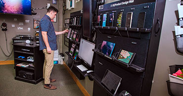 student standing in front of a wall of devices