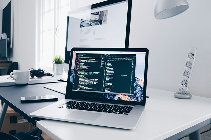 laptop on a desk with code on the screen