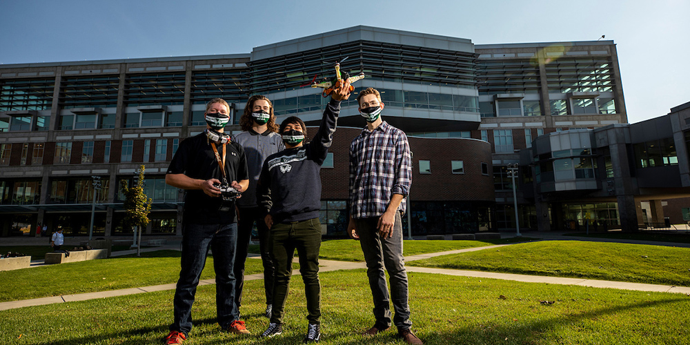 group of students holding a drone