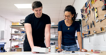 two people looking over papers on a table