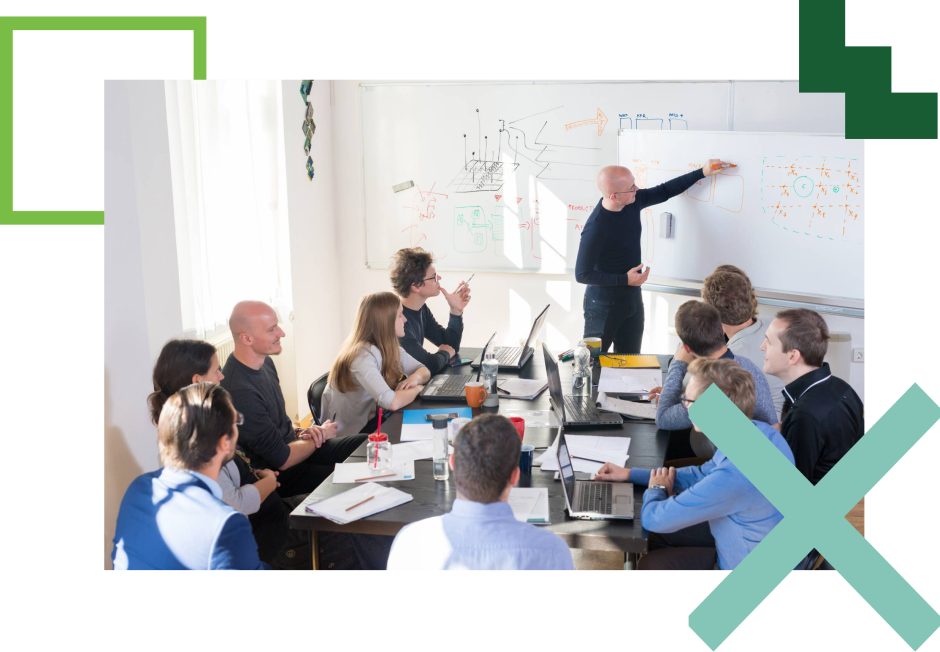 group of people at a conference table looking at a whiteboard