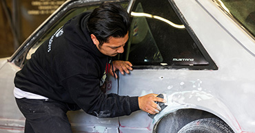 man sanding a car door