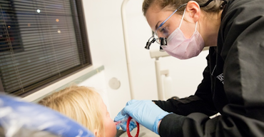 woman doing dental work on a child