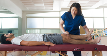 woman holding up a man's leg while he is laying down