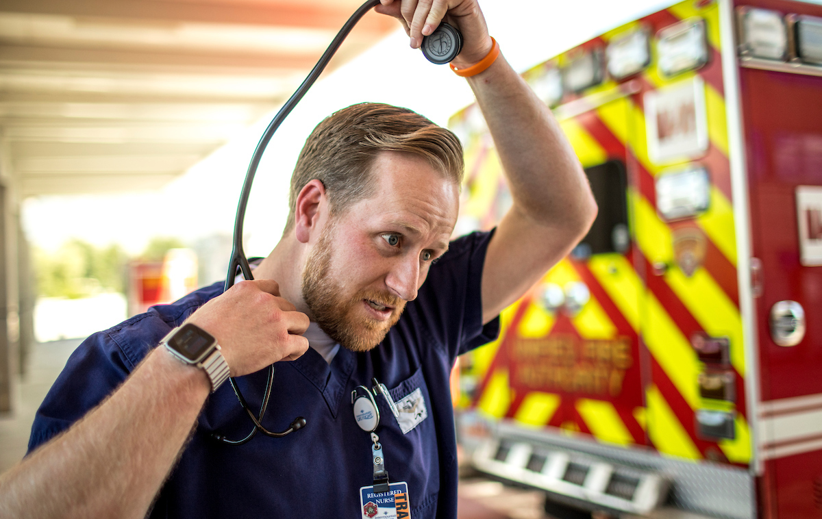Male EMT worker taking a stethescope off his neck.