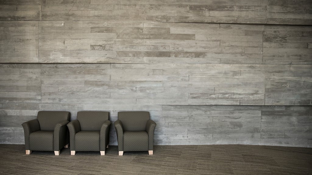 three grey chairs against a grey cement wall