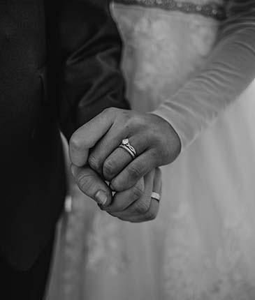 couple holding hands with wedding rings