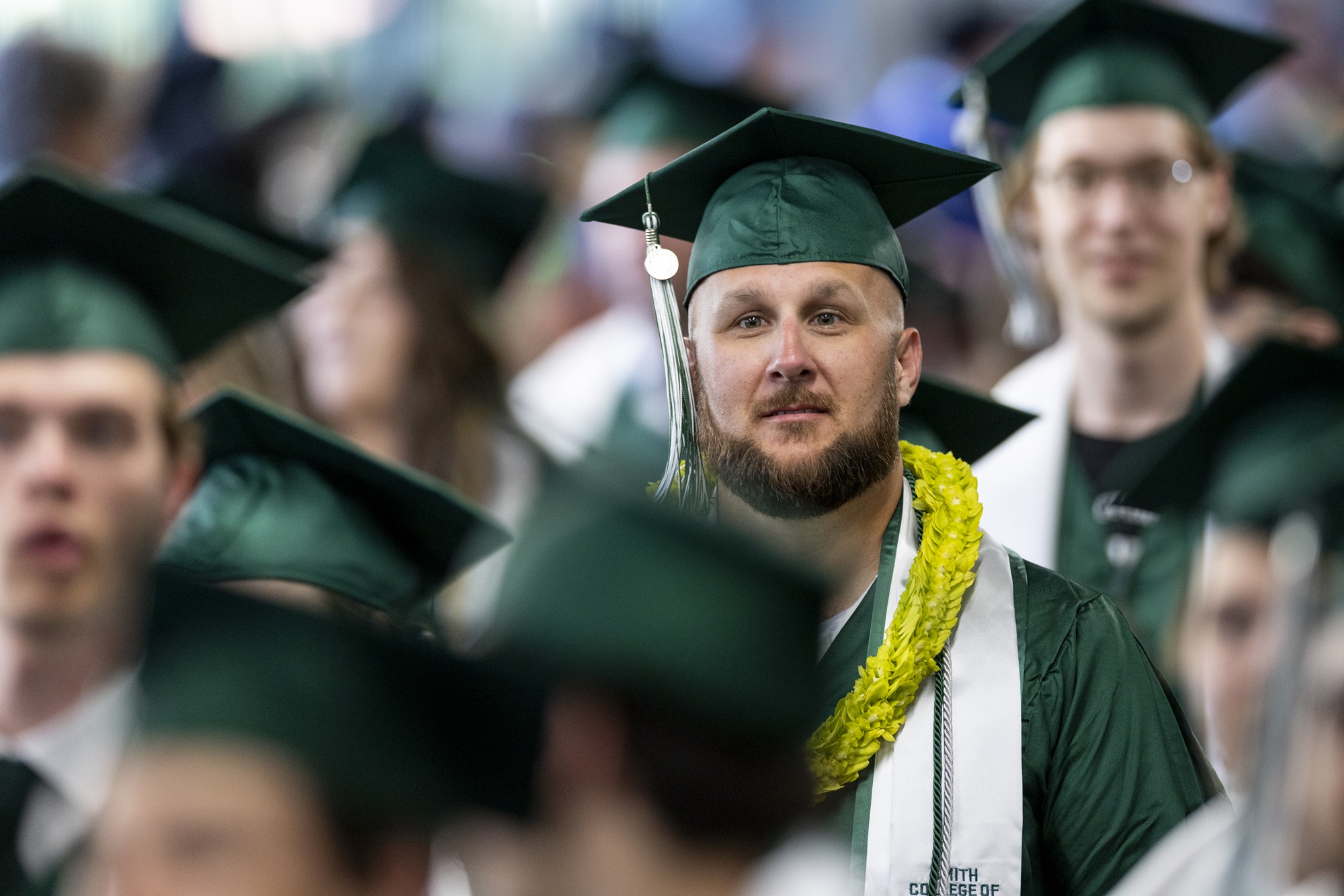 Student wearing green UVU shirt looking out window.
