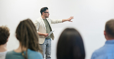 man gesturing at a white board