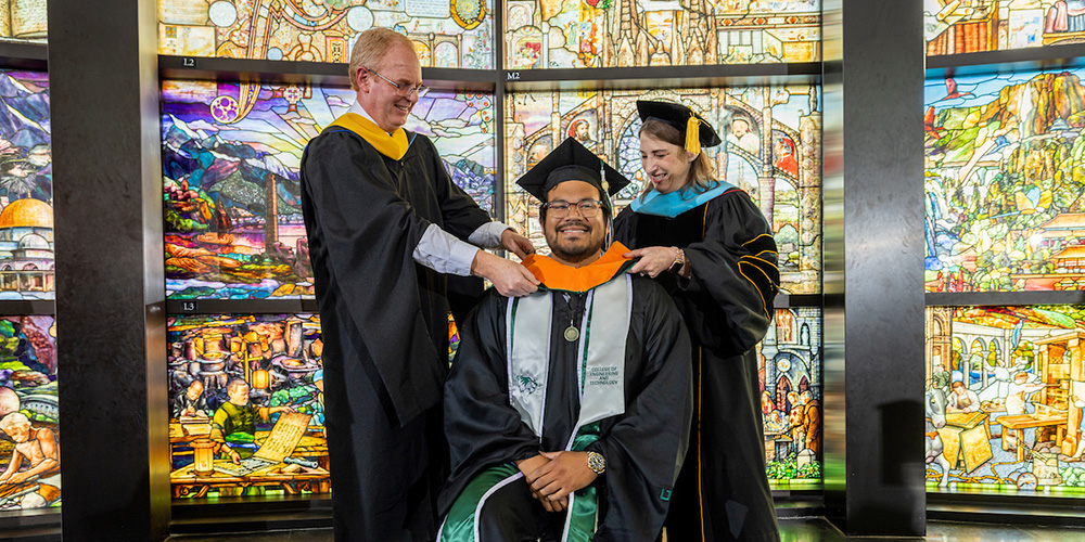 man in master's degree robes receiving a stole