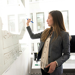 woman writing on a whiteboard