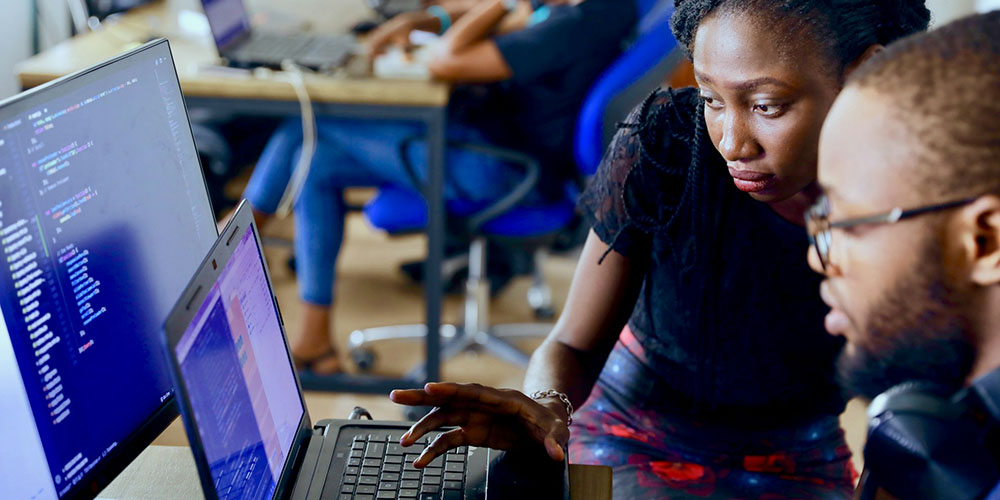 woman helping a man on a laptop