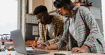 two people looking at a laptop