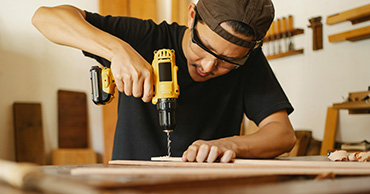 man drilling into a piece of wood