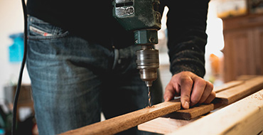 man drilling into a piece of wood