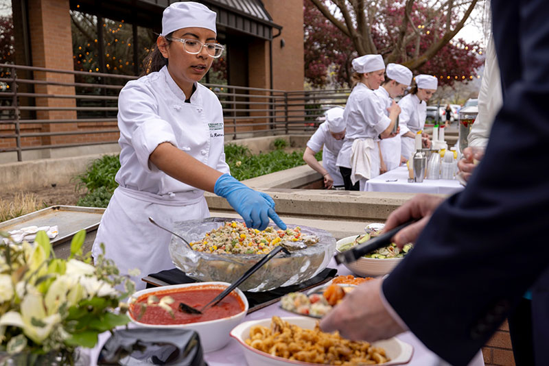 Culinary Arts students serving food in outdoor space