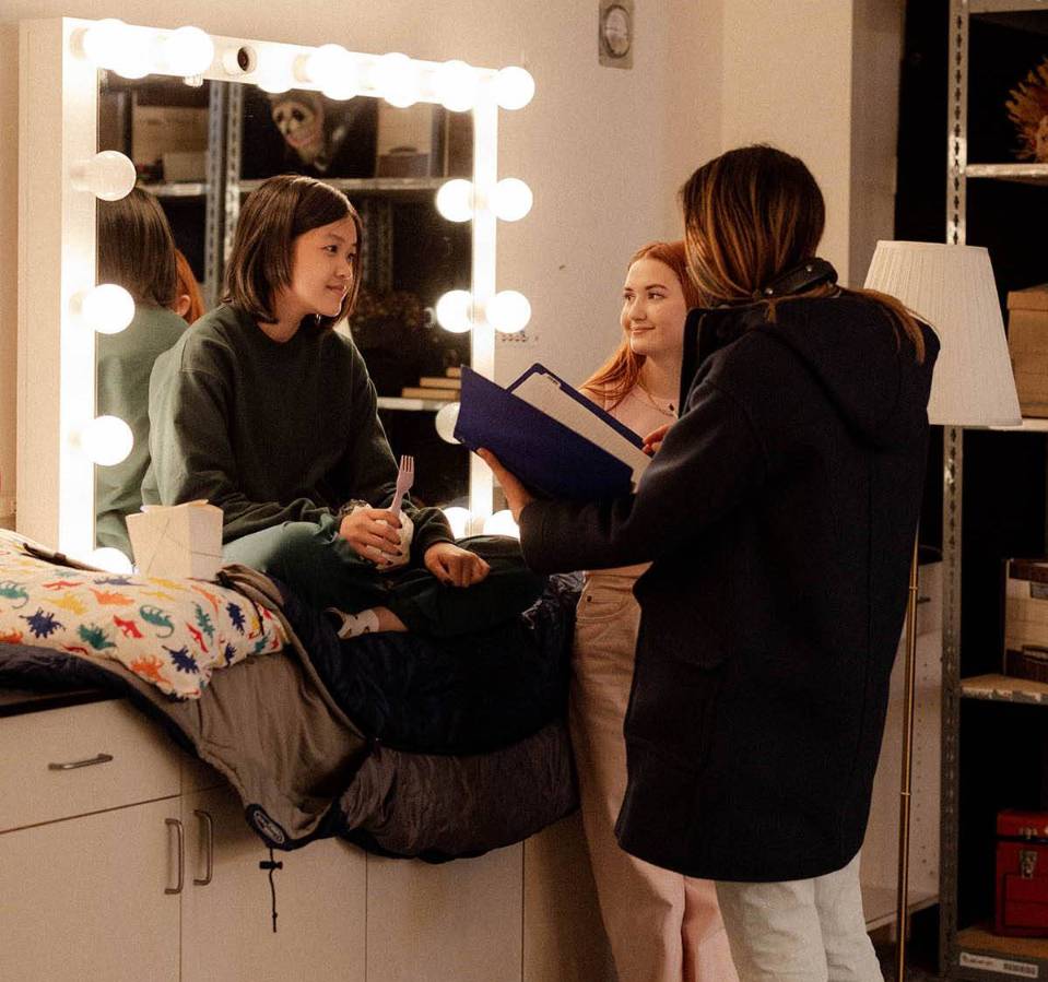 director Lynn Chen working with two actresses in front of a mirror