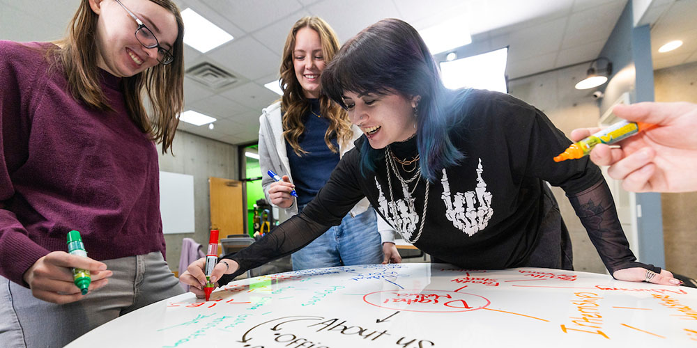 students writing on a white board table