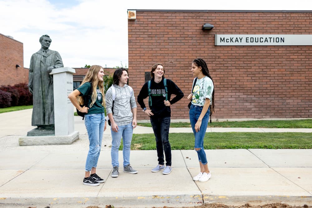 Students visiting with each other outside the education building