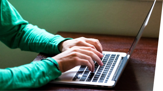 Close-cropped image of person typing on laptop computer.