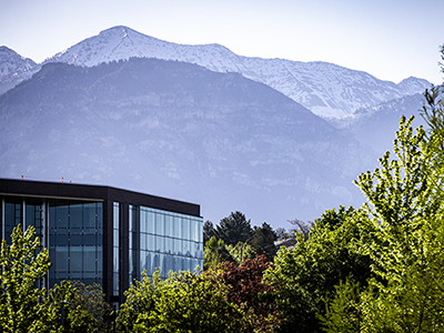 decorative image of foggy mountains with trees and campus in front