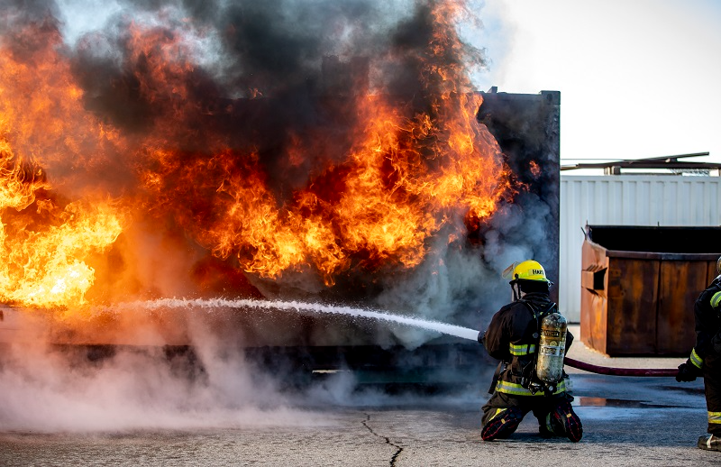 Firefighter putting out a fire with a hose